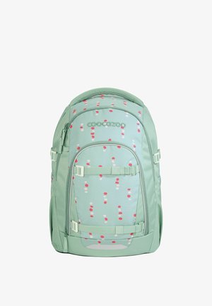 Sac à dos vert avec une finition mate, présentant un motif à pois roses et blancs. Il est équipé de bretelles réglables et de plusieurs compartiments zippés.