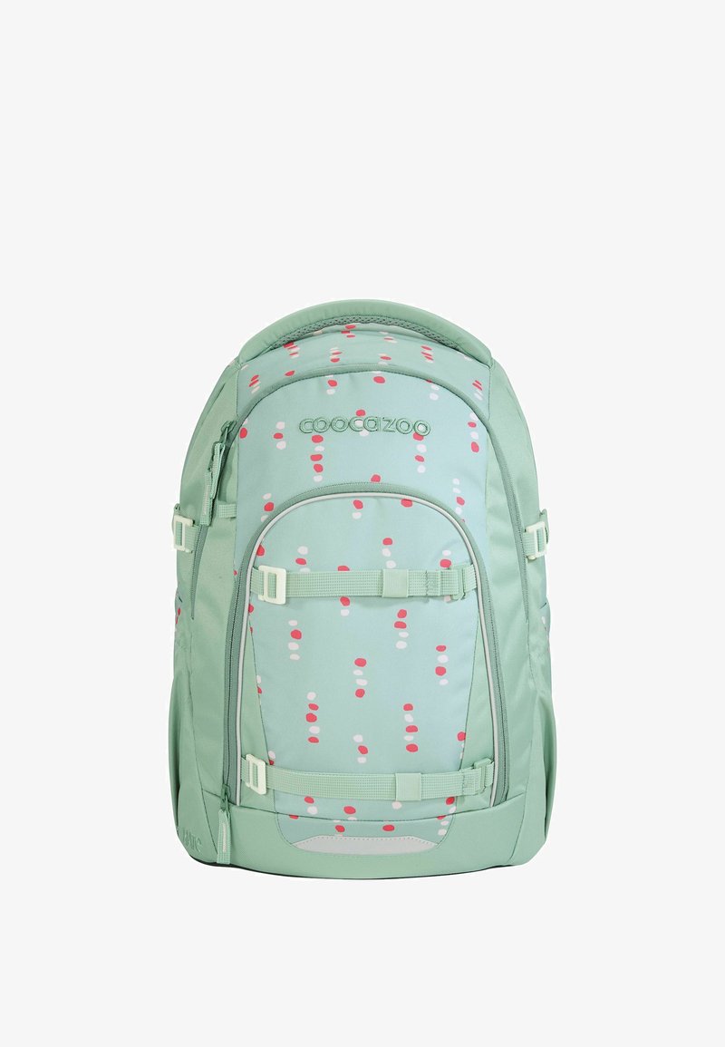 Sac à dos vert avec une finition mate, présentant un motif à pois roses et blancs. Il est équipé de bretelles réglables et de plusieurs compartiments zippés.