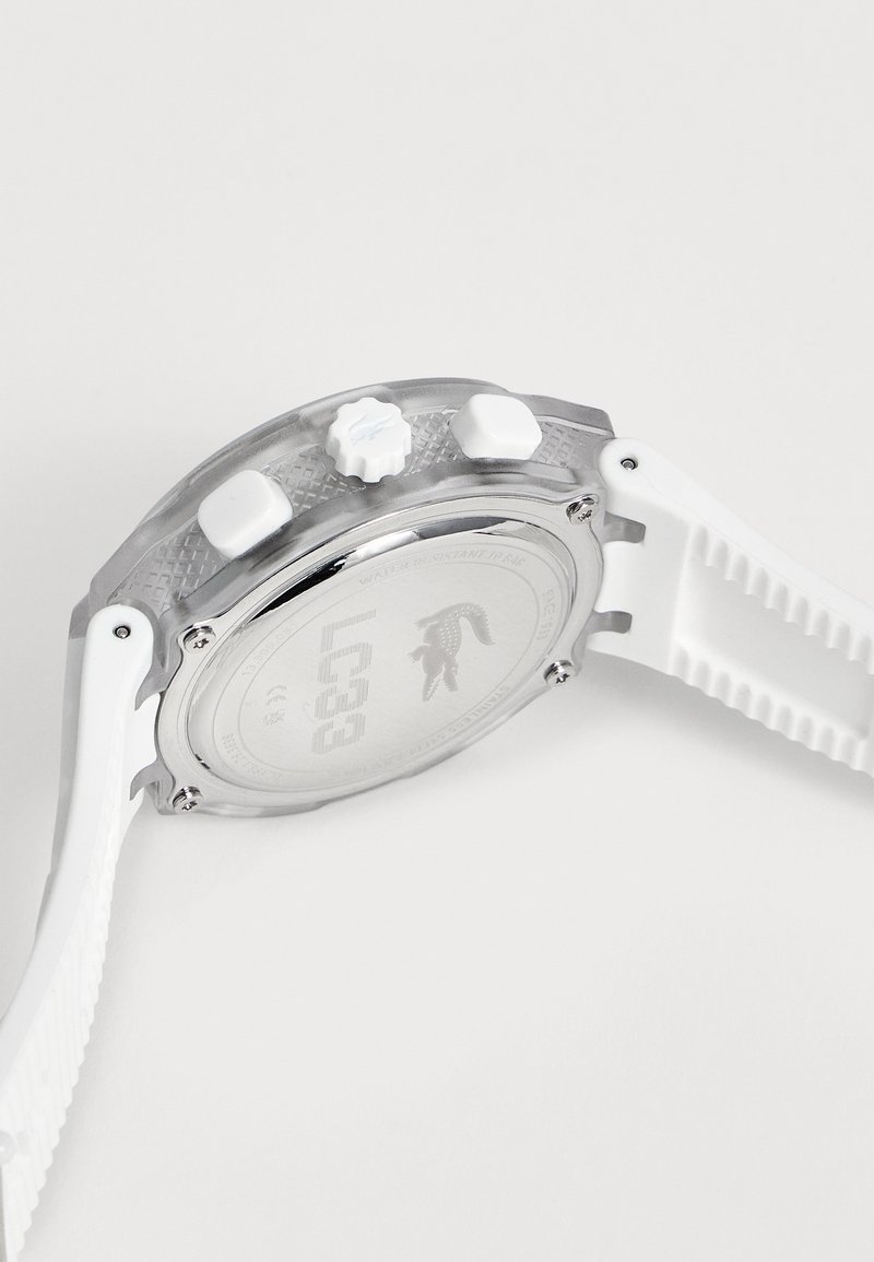 Cassa dell’orologio in argento con tre pulsanti bianchi e cinturino in silicone bianco testurizzato su sfondo uniforme, mostra il retro con logo inciso.