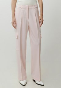 Helle rosa, weit geschnittene Hosen mit Seitentaschen, aus glattem Stoff gefertigt. Sie verfügen über eine hohe Taille und maßgeschneiderte Falten. Perfekt kombinierbar mit hohen Schuhen.