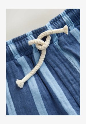 Niebieska i jasno-niebieska tkanina w paski z kremowym, supełkowanym sznurkiem w talii, o teksturowanym i miękkim wyglądzie.