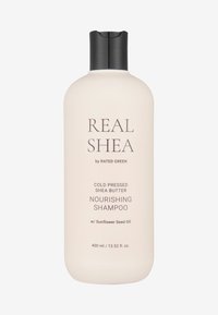 Bottiglia di shampoo nutriente in morbido beige. Contiene burro di karité spremuto a freddo e olio di semi di girasole. Capacità di 400 ml con un tappo nero.