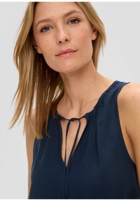 Top senza maniche blu navy con scollatura arricciata e dettaglio con lacci. Tessuto morbido, vestibilità comoda, design minimale, adatto per un abbigliamento casual.
