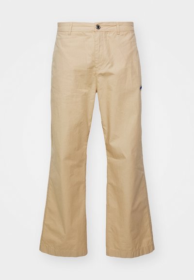 Pantalons évasés beiges en tissu lisse. Présentent des poches avant, une fermeture à bouton et de subtiles rayures texturées.