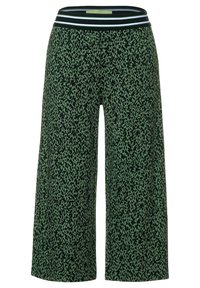 Gröna culotter med ett svart leopardmönster, utrustade med en svart- och vitrandig elastisk midja för ökad komfort och stil.