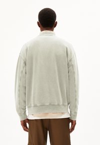 Lichtgrijze, oversized sweatshirt met een zachte textuur, geribbelde mouwen en zoom. Heeft een relaxte pasvorm en een eenvoudig kraagontwerp.