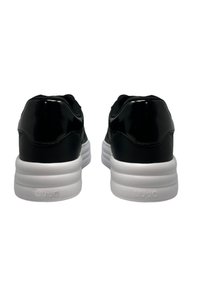 Sneaker in pelle verniciata nera con suole in gomma bianca, tomaia in rete testurizzata e colli imbottiti. Logo del marchio visibile sul tallone.
