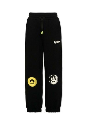 Czarne spodnie dresowe z elastycznymi mankietami i paskiem w talii, z żółtymi i białymi okrągłymi nadrukami łap na kolanach oraz białym logo na górnej części uda.