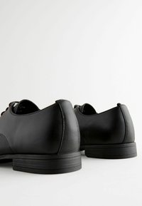 Zwarte leren schoenen met een gladde oppervlak, ronde neus en textuuraccenten op de hak. Eenvoudig vetersluiting ontwerp met een lage profiel.