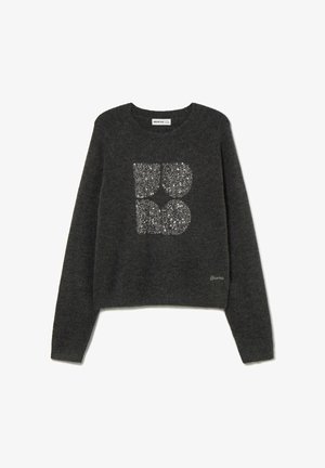 Suéter gris con cuello redondo y mangas largas. Presenta un diseño gráfico brillante, plateado y con purpurina en la parte delantera. Tela suave y texturizada.