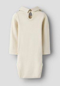 Vestido de algodón color crema con capucha ajustada, mangas tres cuartos y un escote de llave en el cuello. Presenta aberturas laterales para mayor comodidad.