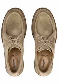 Beige ruskindssko med rund tå, dekorativ snøring og polstret sål. Har en brun gummisål og mærkning indeni.