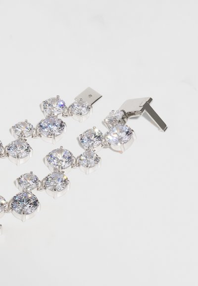 Ασημένιο βραχιόλι με μεγάλες, διαυγείς στρογγυλές κρύσταλλοι τοποθετημένοι σε μεταλλικές λαβές, με σχέδιο κλειδώματος για ασφαλή σύνδεση.