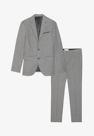 Grå jakkesæt med en slå-om krave blazer og flade bukser. Har en subtil tekstur og en enkelt brystlomme med sort accentstof.