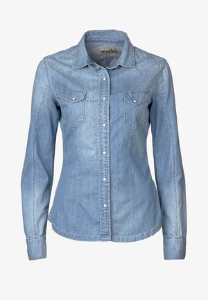 Chemise en jean bleu clair à boutons, manches longues, deux poches à rabat sur le devant et col classique.