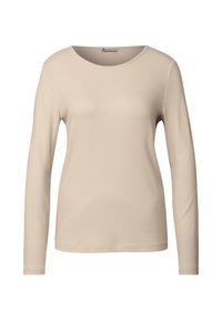 Beige pitkähihaine ribbipaita, jossa on pyöreä pääntie. Kangas on hienoribbaista, mikä tarjoaa kapean siluetin.