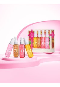 Set di sette bottiglie di spray per capelli colorate in diverse sfumature di rosa e ambra, disposte in una scatola regalo con un'etichetta vivace e un nastro.