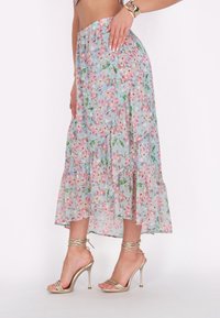 Florale maxi rok van lichtgewicht, doorschijnende stof met een pastelblauwe achtergrond, voorzien van roze en groene bloemenpatronen en gelaagde ruffles.