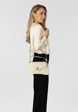 Cremefarbenene Lederschultertasche mit Klappe zum Umschlagen, goldfarbenen Beschlägen und verstellbarem Riemen, vor neutralem Hintergrund platziert.