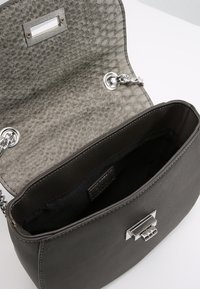 Czarna skórzana torebka z teksturowanym szarym klapą w wzór faux węża. Srebrne akcesoria i łańcuszkowy pasek. Wnętrze wyłożone czarnym materiałem.