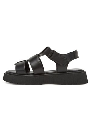 Schwarze Leder-Sandalen mit breiten Riemen, verstellbarer Schnalle und einer dicken, gerillten Sohle. Offenes Design an Zehen und Ferse für atmungsaktiven Tragekomfort.