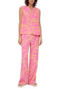 Conjunto de dos piezas en color rosa con un patrón abstracto de hojas naranjas. La parte superior es sin mangas con un escote en V; los pantalones son de pierna ancha y fluidos. Tejido texturizado.