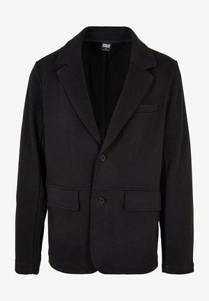 Fekete blézerdzseki puha anyagból, kifordított gallérral, két elülső zsebbel és két gombos záródással. Klasszikus dizájn, minimalista textúrával.