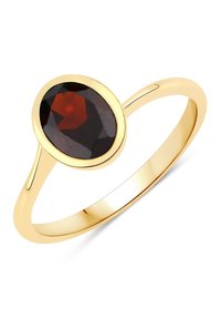 Bague en or ornée d'une pierre précieuse ovale et facettée de couleur rouge foncé. L'anneau est lisse et fin, avec une finition polie.