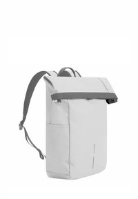 Zaino grigio a roll-top con una tracolla testurizzata, tasca laterale, tessuto liscio e un design minimalista. Accentuato da spallacci regolabili.