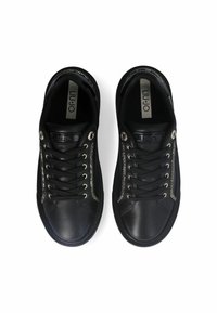 Para czarnych skórzanych sneakerów z czarnymi sznurówkami i srebrnym kamieniem strass wzdłuż boków, widziana z góry na białym tle.