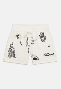 Hvite shorts laget av bomull, med svarte grafiske trykk som inkluderer en tiger, hender, sol og ulike geometriske former. Justerbart midjebånd.