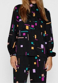 Černá košile s barevnými geometrickými vzory v odstínech růžové, oranžové, fialové a tyrkysové. Dlouhé rukávy s elastickými manžetami, s předním zapínáním na knoflíky a kapsami.