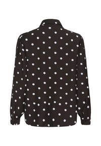 Črna majica z dolgimi rokavi z belimi pikami, ovratnikom na gumbe in gumbi na manšetah. Gladek tekstura z ohlapnim krojem.