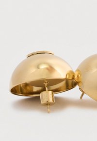 Στρογγυλά σκουλαρίκια από χρυσό με γυαλιστερή επιφάνεια και υφασμένο εσωτερικό. Διαθέτουν κεντρική βάση με μεταλλική πλάτη για κλείσιμο.