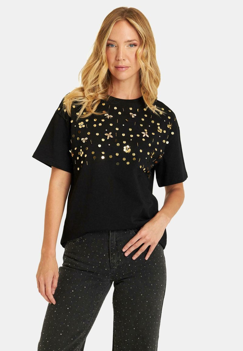 Zwarte katoenen t-shirt met gouden en zilveren bloemenpailletten en metallic stippen op de voorkant. Korte mouwen, relaxte pasvorm, ronde hals.