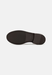 Bruine lederen schoenzool met een licht gestructureerde oppervlakte, voorzien van een ronde neus, gladde randen en subtiele branding.