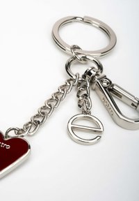 Metalowy brelok z srebrnym łańcuchem, z czerwonym serduszkiem i stylizowanym zawieszką w kształcie litery 'e', przymocowany do mocnego zatrzasku.