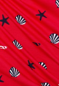 Red fabric featuring a repeating pattern of black starfish and striped seashells, with a smooth, slightly textured surface.