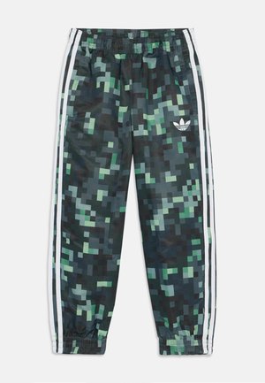 Pantalones jogger de camuflaje con un patrón pixelado en verde y negro. Cuentan con una cinturilla elástica y franjas laterales blancas con un pequeño logotipo.