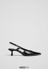 Chaussure noire en cuir à talon kitten, bout pointu et bride de cheville ajustable, présentée sur un fond clair uni.