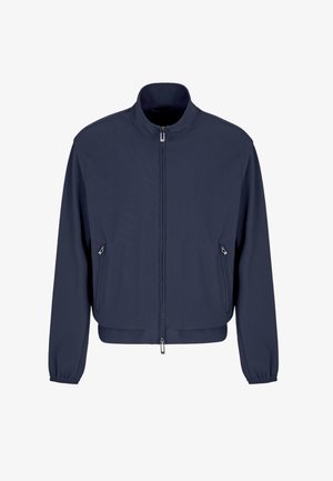 Giacca bomber blu navy realizzata in tessuto liscio, con colletto alto, chiusura frontale con zip e due tasche laterali con zip. Polsini elasticizzati.