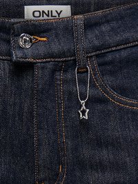 Ciemnoniebieskie dżinsy z pomarańczowym przeszyciem, metalowym guzikiem, białą metką "ONLY" oraz małym srebrnym zawieszonym na łańcuszku gwiazdkowym charms.