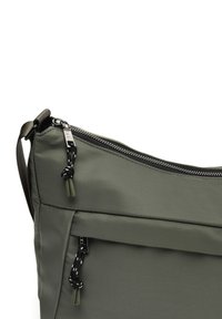 Borsa a spalla verde in nylon con un design elegante, dotata di una cerniera nera e di tiranti decorativi. Finitura testurizzata con una tasca anteriore piatta.