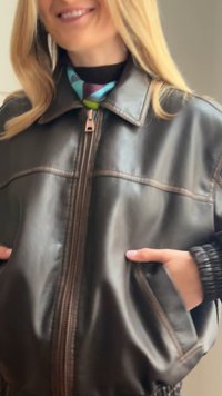 Brun läderjacka med dragkedja fram, två sidofickor och ribbstickade ärmar. Slät textur med kontrasterande sömnadsdetaljer.