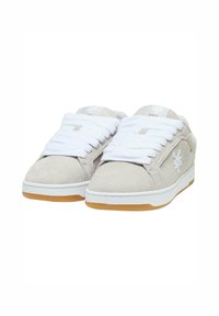 Sneakers with a light gray suede upper, white laces, and a rubber gum outsole; features a logo on the side and padded collar.