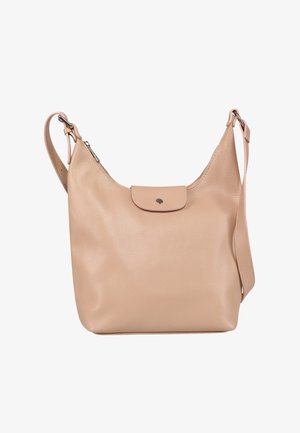 Beige leren schoudertas met verstelbare band, ritssluiting aan de bovenkant en voorflap met drukknoopsluiting.