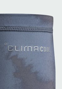 Športové legíny v tmavomodrej látke s technológiou odvádzania vlhkosti, rebrovanou textúrou a strieborným logom "CUIMACOOl".