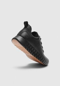 Sort læder sneaker med tekstureret sål, trækflap på hælen og unikt rillede mellemsål design, vist fra en bag-sidde vinkel.