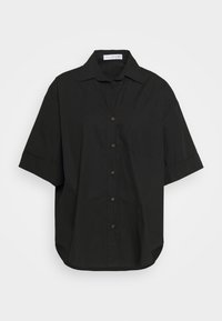 Camicia nera a maniche corte con bottoni, realizzata in cotone, dotata di colletto a risvolto, taschino sul petto e bottoni marroni sul davanti. Orlo arrotondato.