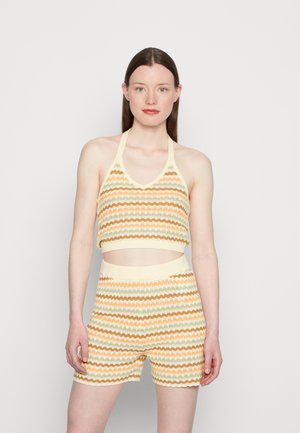 Conjunto de top e calções de malha com um padrão ondulado em amarelo pastilha, laranja e verde. O top tem um design de halter e é cortado.